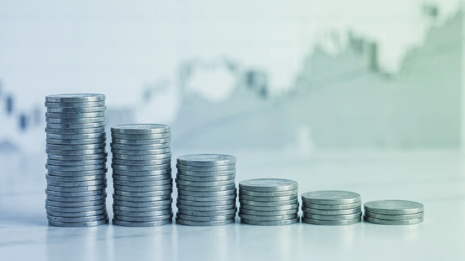 Diminution des frais bancaires symbolisée par des piles d'euros décroissantes